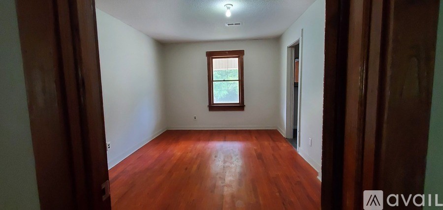 A room with wooden floors and a window.