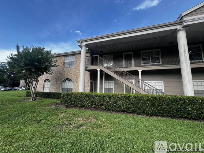A building with a balcony and a tree in front of it.