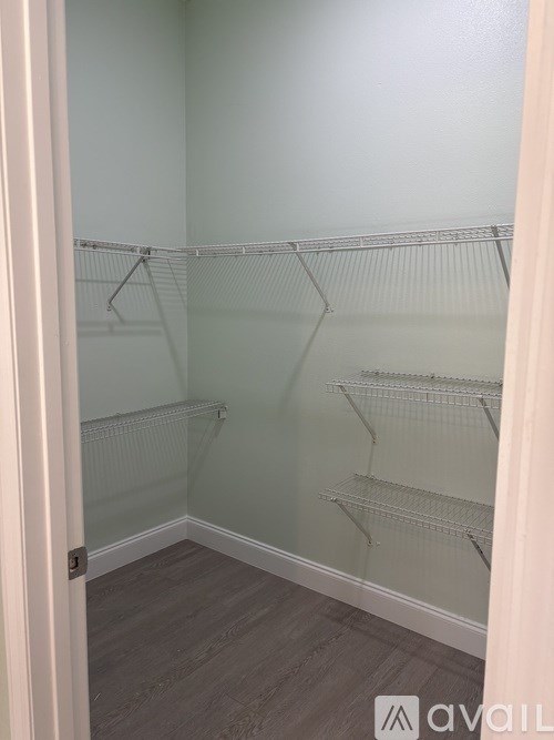 A walk-in closet with shelving and a white door.