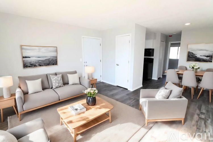 A living room with a grey couch, a wooden coffee table, and a painting on the wall.