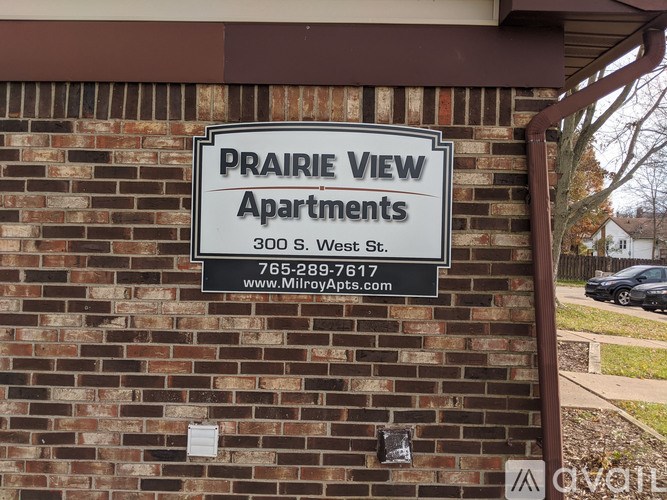 A sign for Prairie View Apartments is mounted on a brick wall.