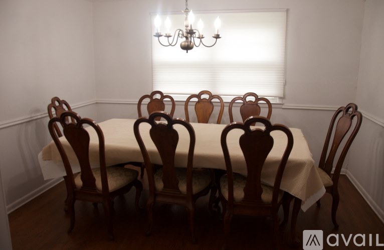 A dining table with chairs and a chandelier in a room.