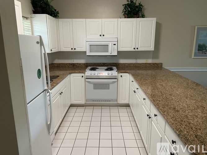 A kitchen with white cabinets and appliances.