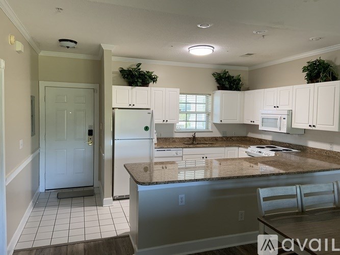 A kitchen with white cabinets and a granite countertop.