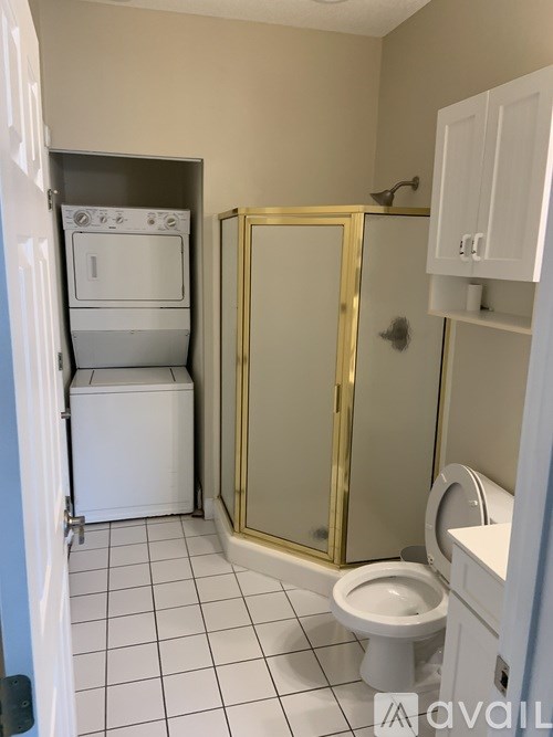 A small bathroom with a toilet, a cabinet, and a microwave.