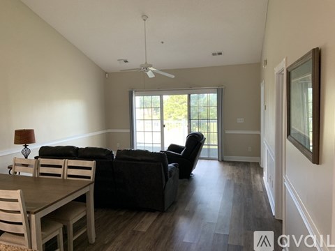 A living room with a black couch and a wooden table.