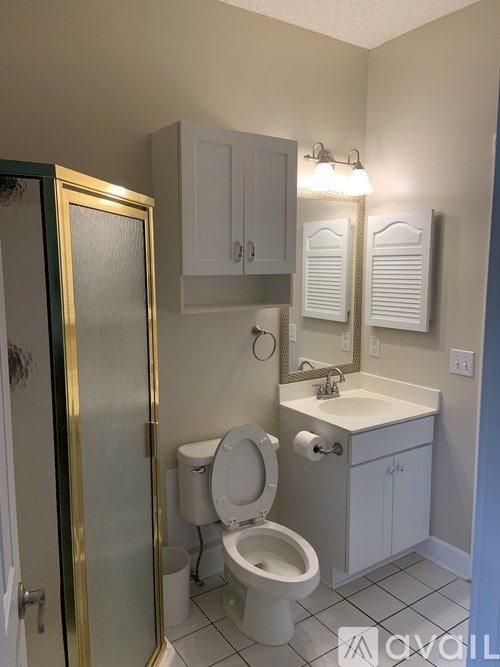 A bathroom with a toilet, sink, and medicine cabinet.
