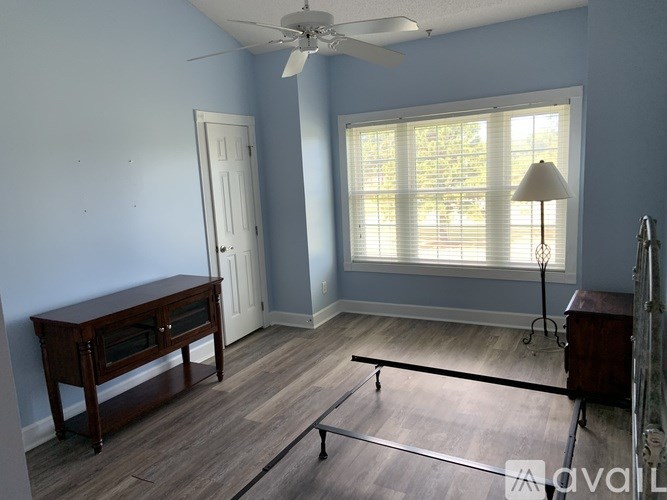A room with a wooden table and a fan.