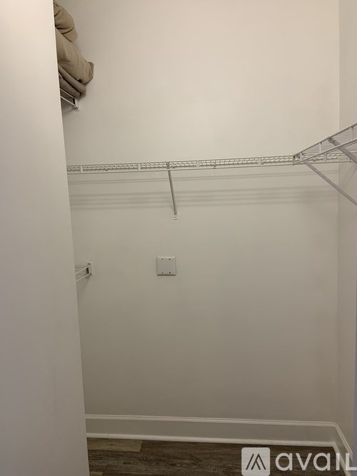 A white wall with a shelf and a light switch.