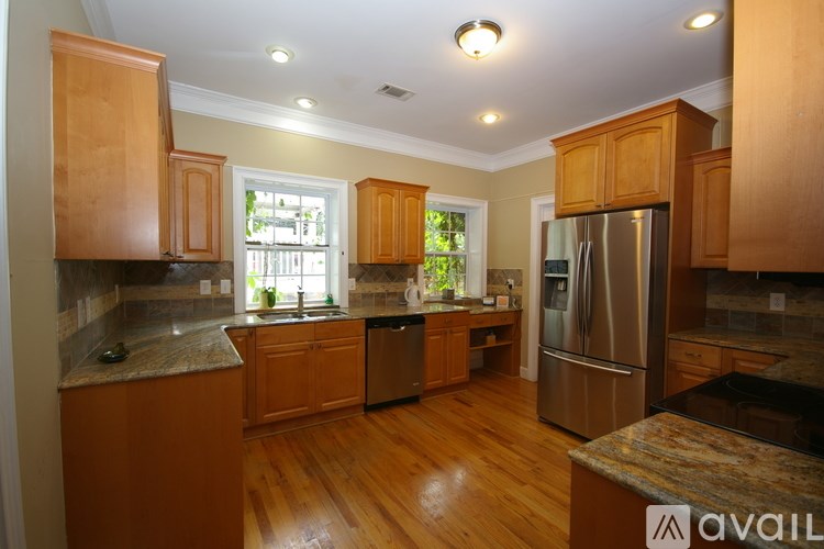 A kitchen with wooden cabinets and a refrigerator.