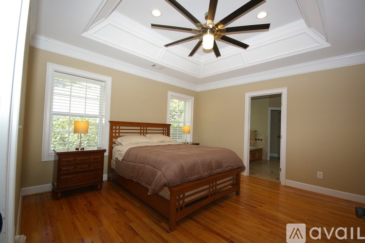 A bedroom with a bed, dresser, and window.