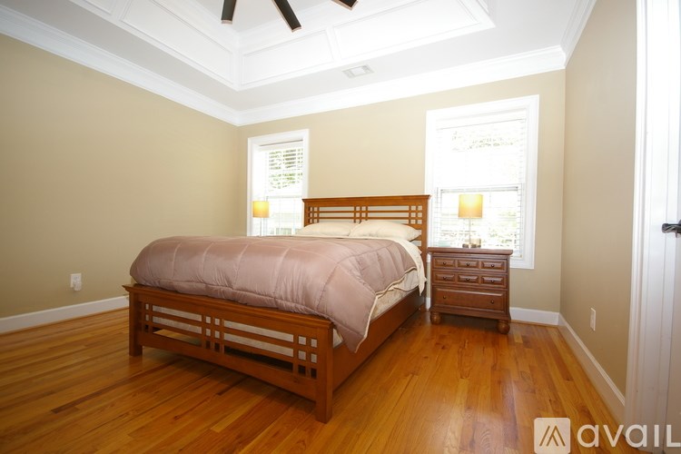 A bedroom with a bed, dresser, and window.