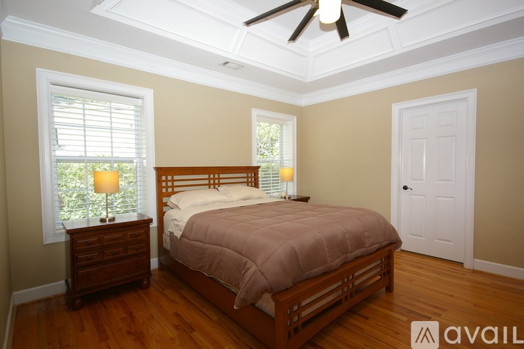 A bedroom with a bed, dresser, and window.