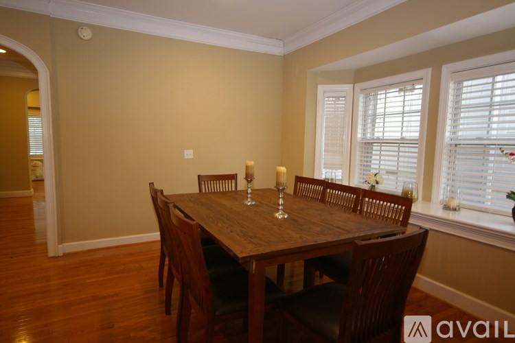 A dining room with a wooden table and chairs.