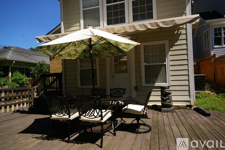 A patio with a table and chairs under an umbrella.
