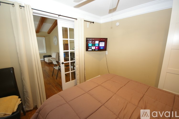A bedroom with a bed, a chair, and a television.