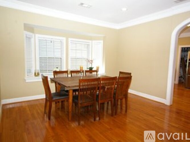 A dining room with a wooden table and chairs.