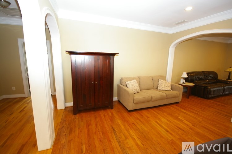 A living room with a brown wooden floor and furniture.