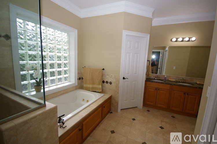 A bathroom with a tub, sink, and window.