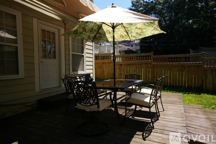 A patio with a table and chairs under an umbrella.