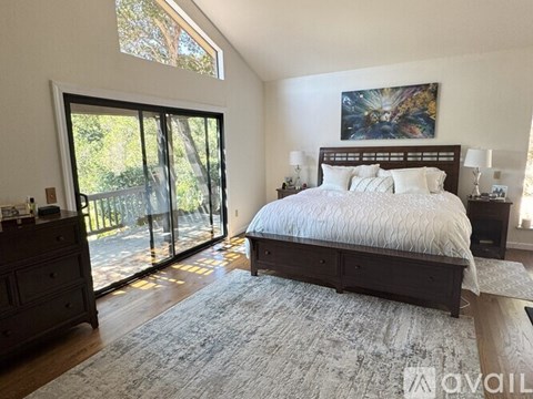 A bedroom with a large bed and a painting on the wall.