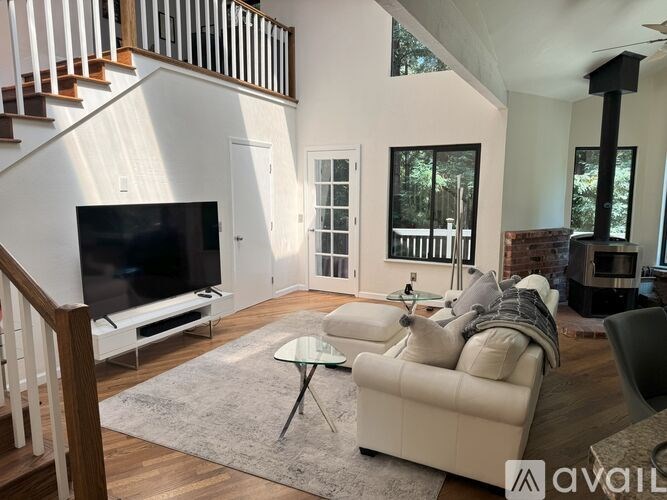 A living room with a television, couch, and a glass table.