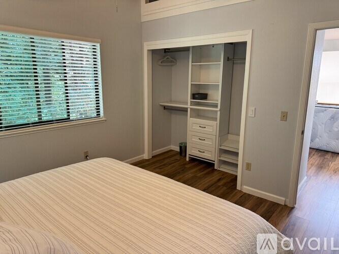 A bedroom with a large bed and a walk-in closet.