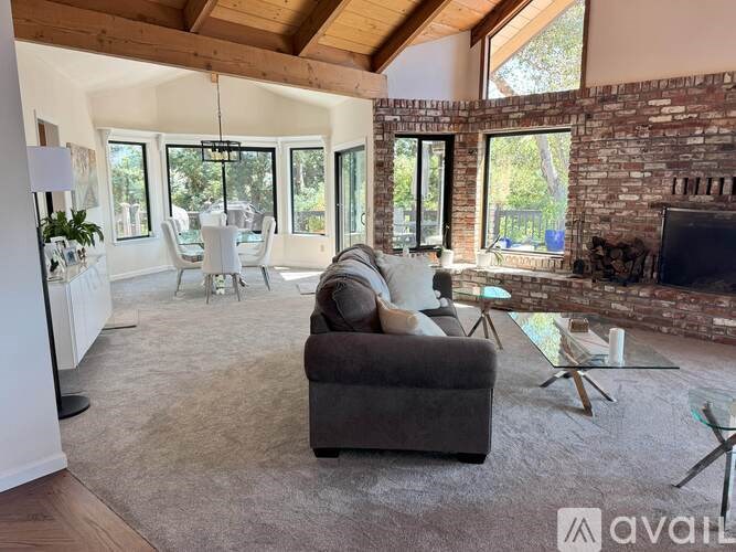 A living room with a couch, chairs, and a fireplace.
