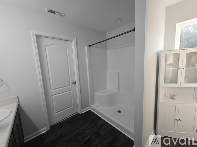A white bathroom with a tub and sink.