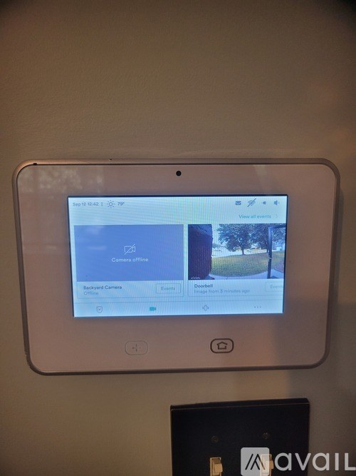 A tablet is mounted on a wall with a camera offline screen displayed.