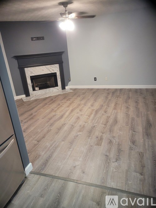 A room with a fireplace and wooden flooring.