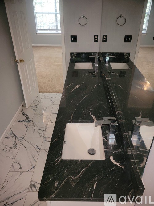 A bathroom with a marble countertop and a white sink.