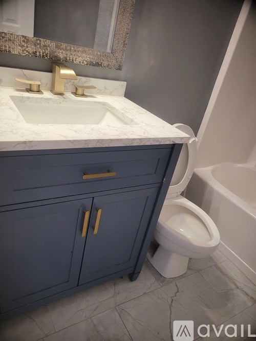 A bathroom with a toilet, sink, and mirror.