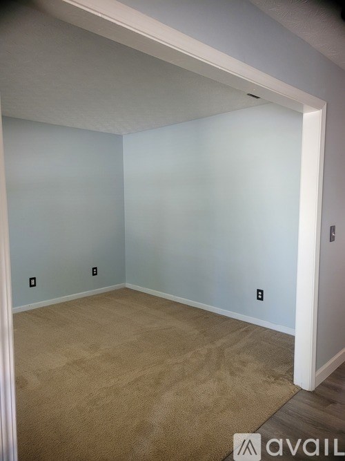 A room with a carpeted floor and a white door.