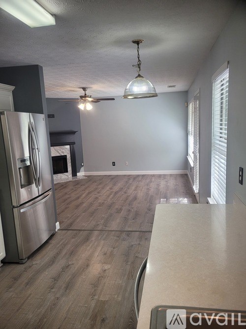 A kitchen with a refrigerator and a ceiling fan.