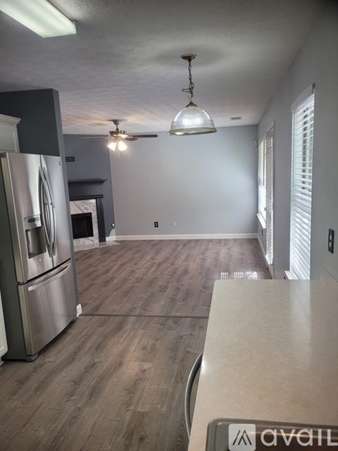 A kitchen with a refrigerator and a ceiling fan.