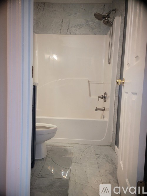 A white bathroom with a toilet and a bathtub.