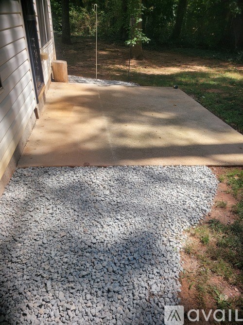 A concrete patio with a gravel area in the middle.