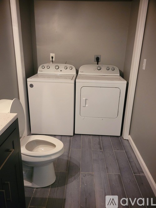 A bathroom with a toilet and two washing machines.