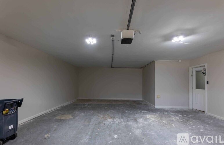 A room with a concrete floor and a white door is available for rent.