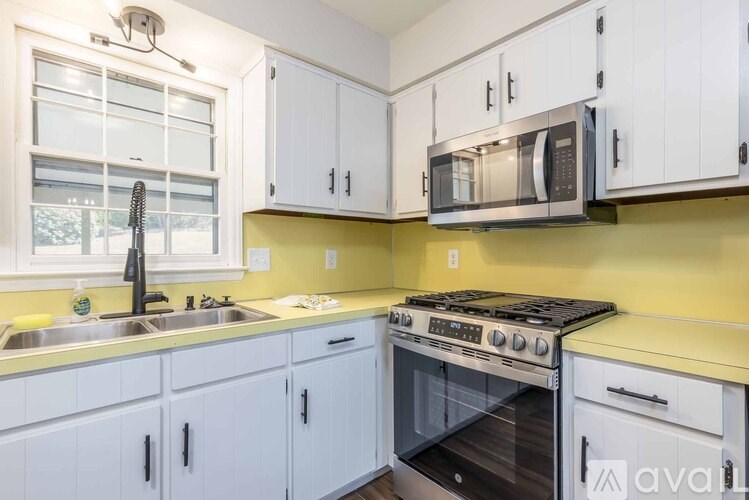 A kitchen with white cabinets and a yellow backsplash.