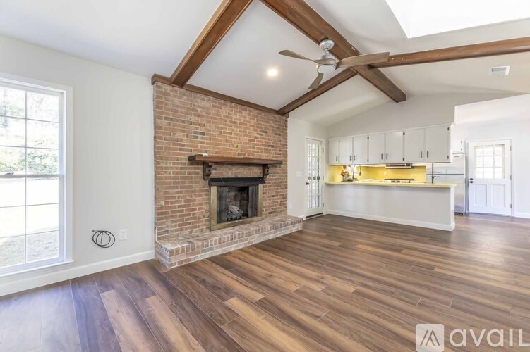 A living room with a fireplace and a ceiling fan.