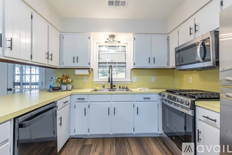 A kitchen with white cabinets and a yellow backsplash.
