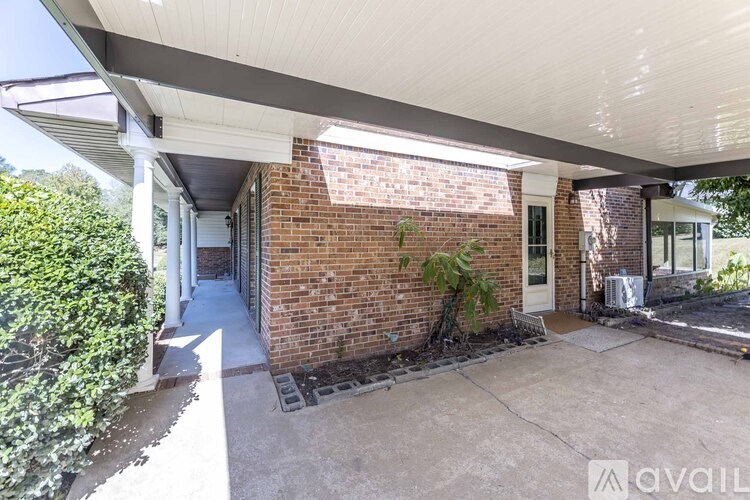 A house with a covered patio and a brick wall.