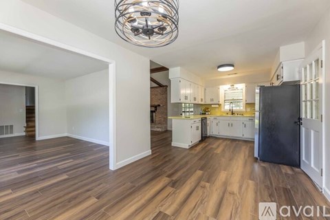A spacious family room with a fireplace and wooden floors.