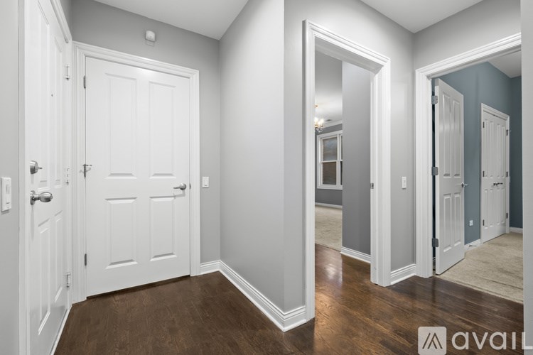 A hallway with white doors and a wooden floor.