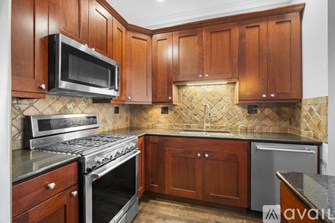 A kitchen with wooden cabinets and a tiled backsplash.