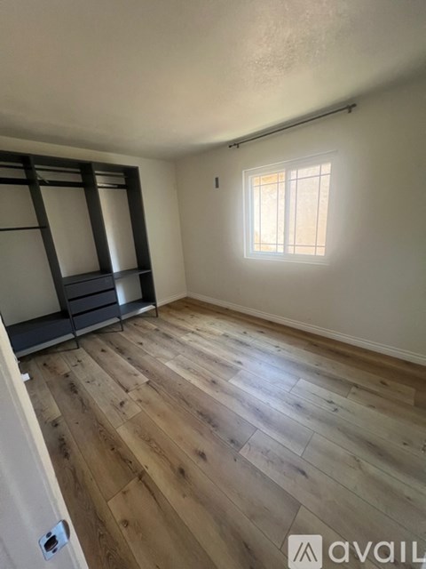 A room with wooden flooring and a window.