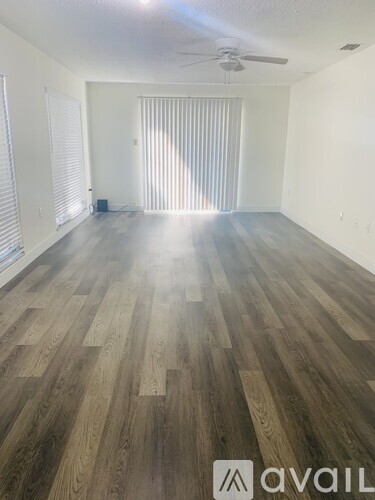 A room with wooden flooring and a ceiling fan.