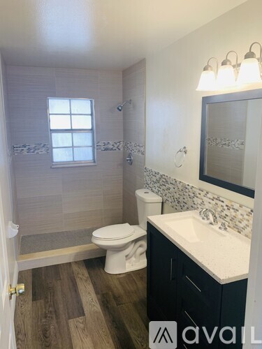 A bathroom with a toilet, sink, and shower.